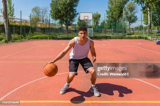 young man playing basketball - dribbling sport fotografías e imágenes de stock