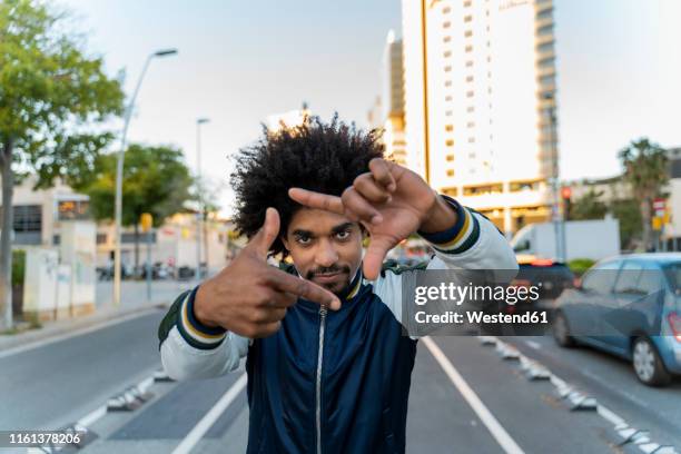 portrait of casual man in the city making a finger frame, barcelona, spain - fingerrahmen stock-fotos und bilder