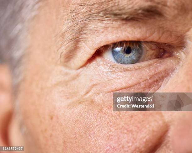 blue eye of mature man - blue eyes stock pictures, royalty-free photos & images