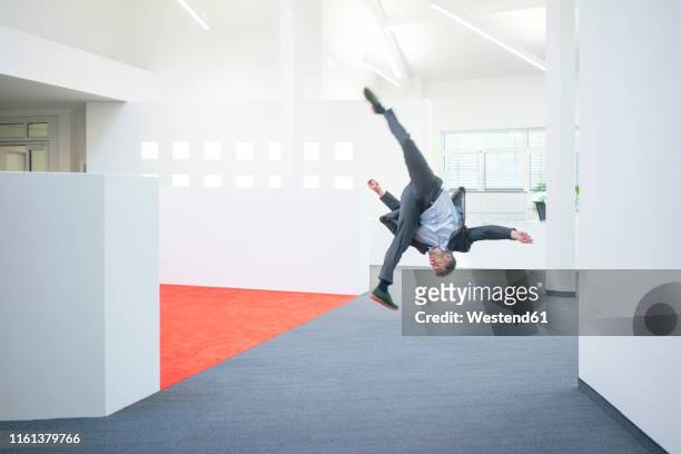 businessman jumping mid-air on office floor - somersault stock pictures, royalty-free photos & images