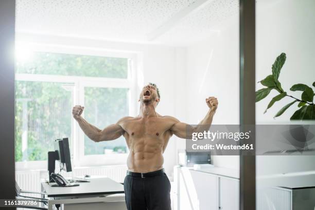 screaming barechested businessman flexing muscles in office - macho stockfoto's en -beelden