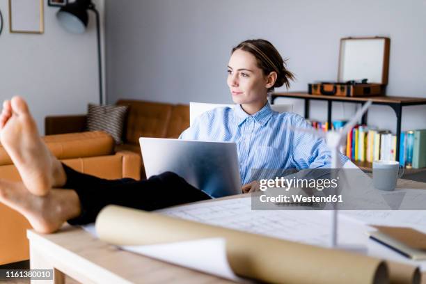 woman in office working on laptop with feet on table - female foot models ストックフォトと画像