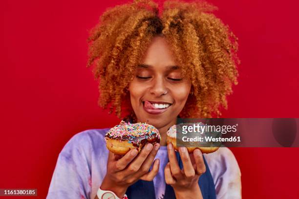 woman choosing which donut to eat - holding two things foto e immagini stock