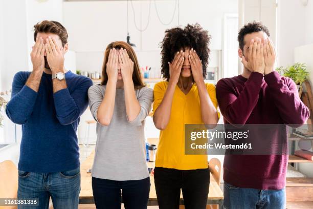 four friends standing side by side at home covering their faces - see no evil stock pictures, royalty-free photos & images