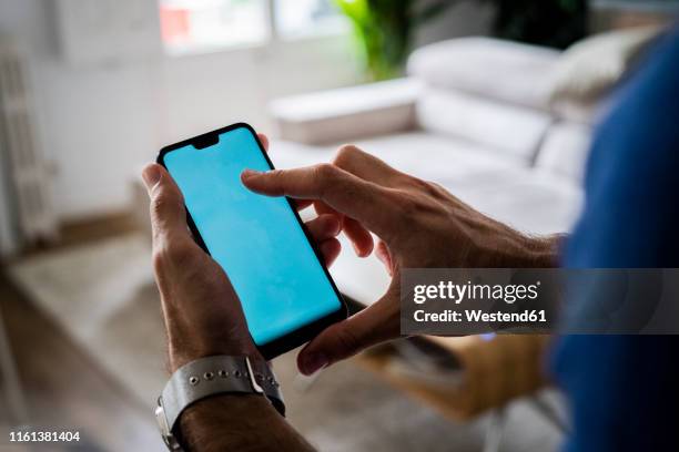 close-up of man using cell phone at home - mann handy couch stock-fotos und bilder