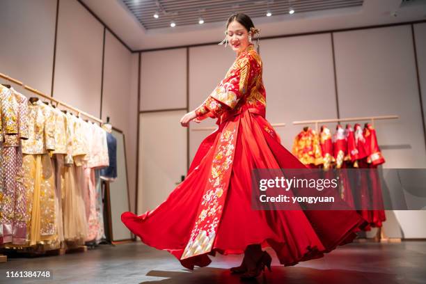 young woman trying on a traditional wedding dress - silk garment stock pictures, royalty-free photos & images