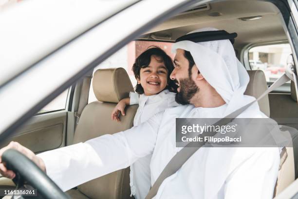 arabischer vater im auto mit seinem sohn - arab driving stock-fotos und bilder