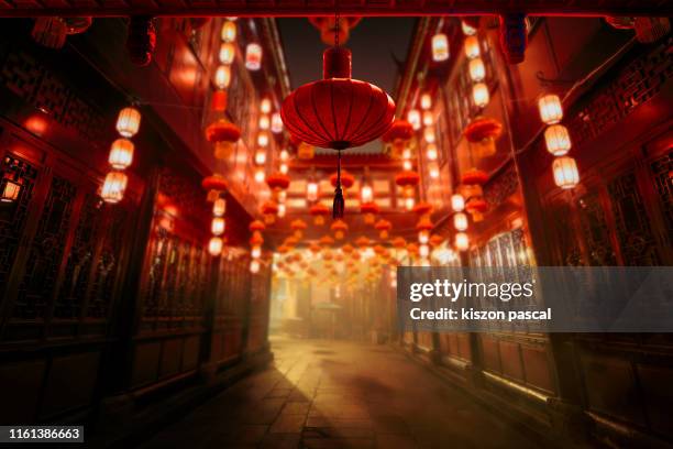 the traditional red lanterns illuminated at night in a street of chengdu in sichuan during a chinese new year . chinese culture . - lanterna cinese foto e immagini stock