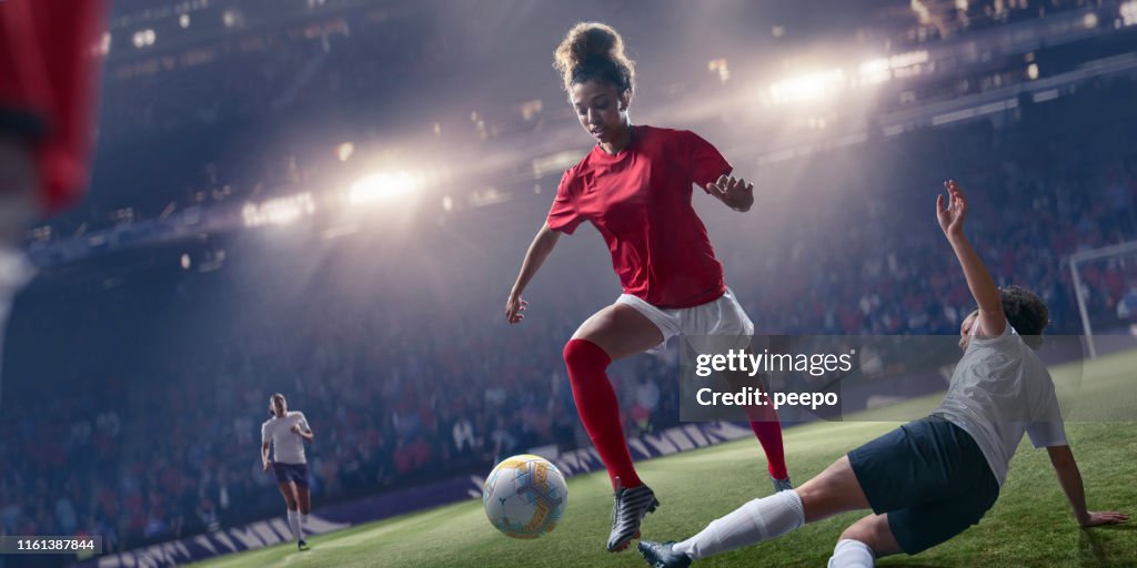 Professionele vrouw Soccer Player springen over glijden Tackle tijdens de wedstrijd