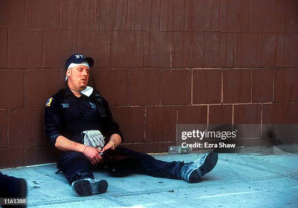 An emergency worker takes a break from the rescue effort after the World Trade Center's twin towers collapsed after being struck by commerical...