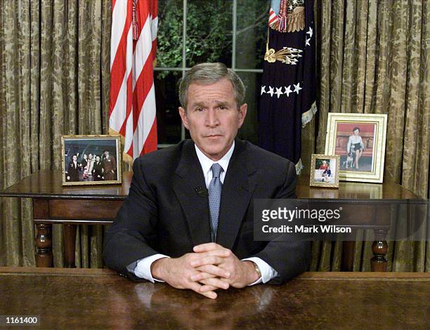 President George W. Bush sits at his desk in the Oval Office after addressing the nation about the terrorist attacks on New York and Washington, DC...
