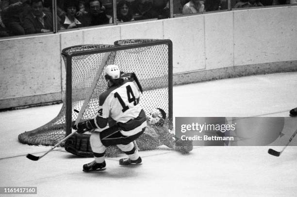 Penguins' Wayne Bianchin hits Red Wings' goalie, Jim Rutherford, with spray of ice as he knocks puck into the net to score in 1st period of game....