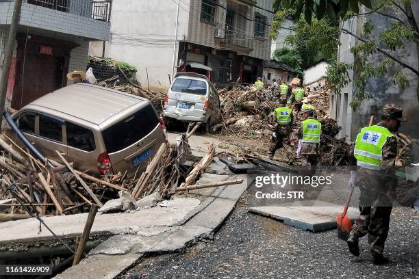 This photo taken on August 12, 2019 shows rescuers working in the aftermath of Typhoon Lekima in Linan in China's eastern Zhejiang province. - The...