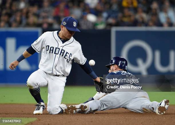 Luis Urias of the San Diego Padres drops the ball as Kevin Kiermaier of the Tampa Bay Rays steals second base during the fourth inning of a baseball...