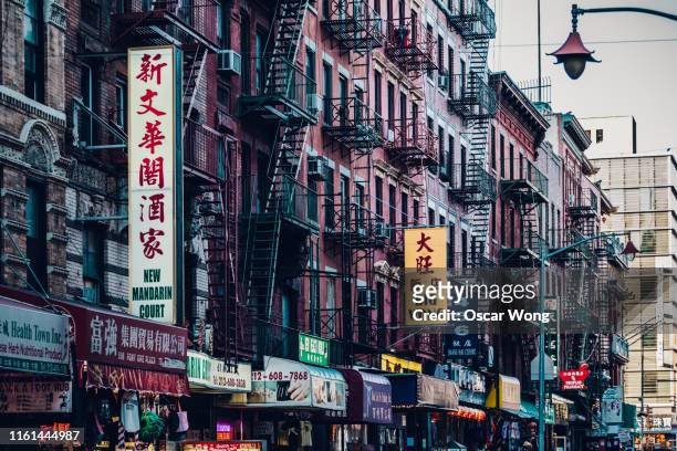 buildings facades in manhattan chinatown, new york, usa - chinatown stock-fotos und bilder