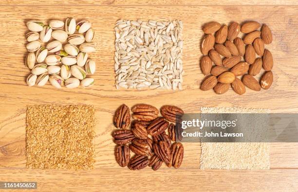 nuts and seeds on a wooden background - magnesium metal stock pictures, royalty-free photos & images