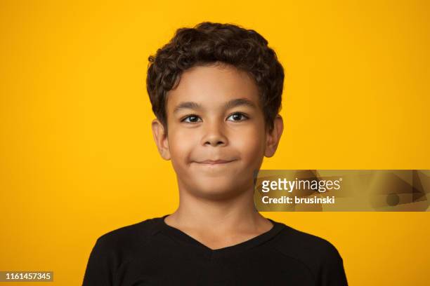 close-up studio portret van een 12-jarige jongen op een gele achtergrond - 10 11 jaar stockfoto's en -beelden