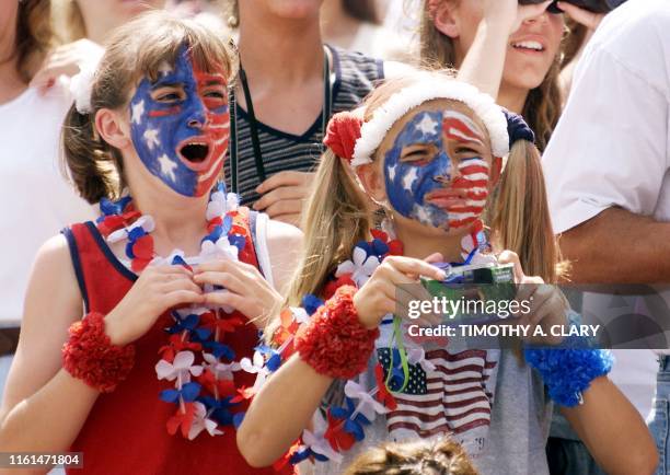 Young girls with their faces painted like the US flag cheer as the teams come onto the field before the first round game against the US and Denmark...