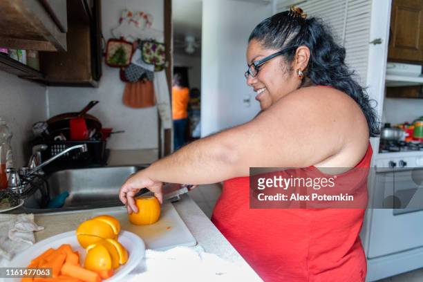 身體積極美麗的墨西哥裔美國婦女做水果沙拉在家庭廚房 - big cook 個照片及圖片檔