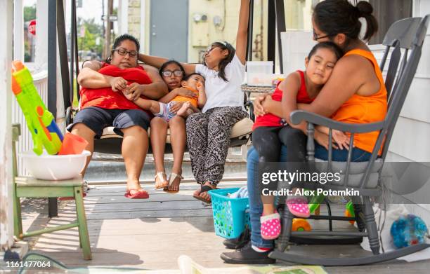 la gran familia mexicana-estadounidense latina feliz descansando en el porche de su casa - hot mexican girls fotografías e imágenes de stock