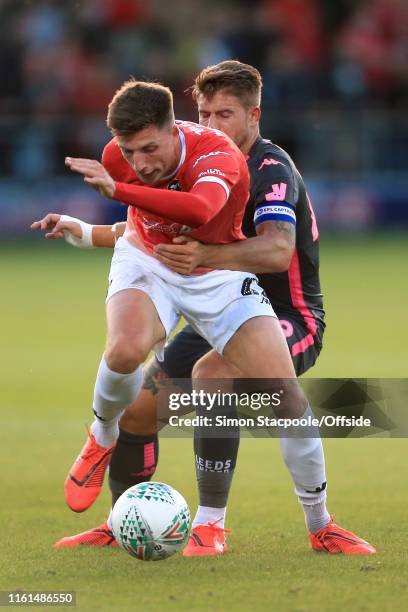 Jake Beesley of Salford battles with Gaetano Berardi of Leeds during the Carabao Cup First Round match between Salford City and Leeds United at Moor...