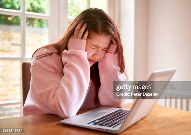 teenager crying using laptop - online bullying foto e immagini stock