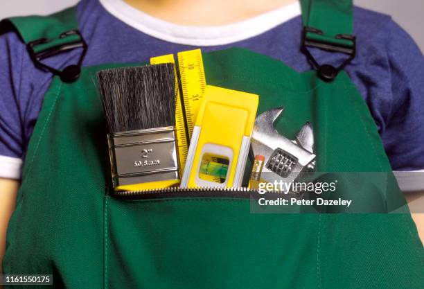female apprentice doing house repairs - bib overalls 個照片及圖片檔