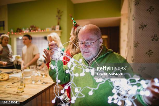 aufstellen von weihnachtsdekorationen - tangled christmas lights stock-fotos und bilder