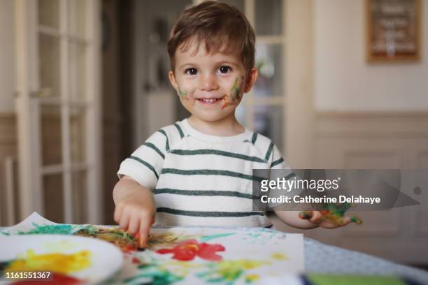 a 2 years old boy doing painting at home - 2 3 years stockfoto's en -beelden