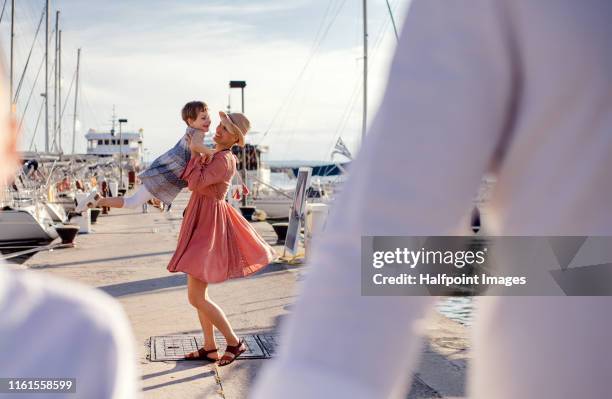a mother with small girl outdoors on dock, having fun. - tournoyer photos et images de collection