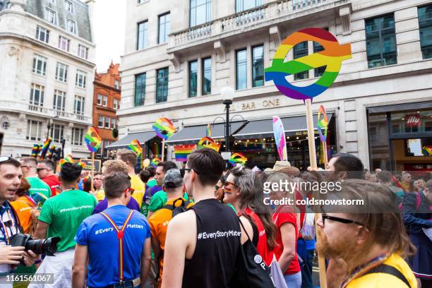 crowds of happy people celebrating at gay pride parade on streets of central london, uk - pride london stock pictures, royalty-free photos & images