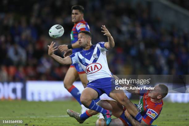 Brandon Wakeham of the Bulldogs is tackled by Shaun Kenny-Dowall of the Newcastle Knights during the round 17 NRL match between the Newcastle Knights...