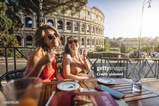 tourist women at bar under the coliseum of rome - romano imagens e fotografias de stock