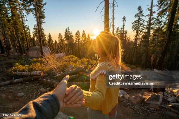 follow me to concept; young woman leading boyfriend to forest in autumn - follow me stock pictures, royalty-free photos & images