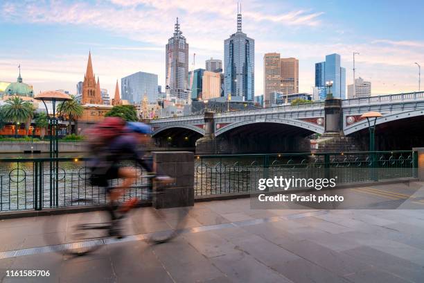 australian people cycling  for exercise near yarra river with view of the melbourne city financial district with skyscrapers in morning at melbourne, victoria, australia. - melbourne ストックフォトと画像