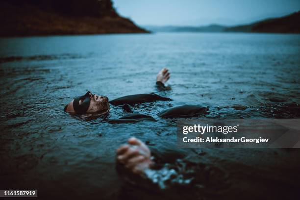 masked vigilante swimming in the after a fight - movie actor stock pictures, royalty-free photos & images