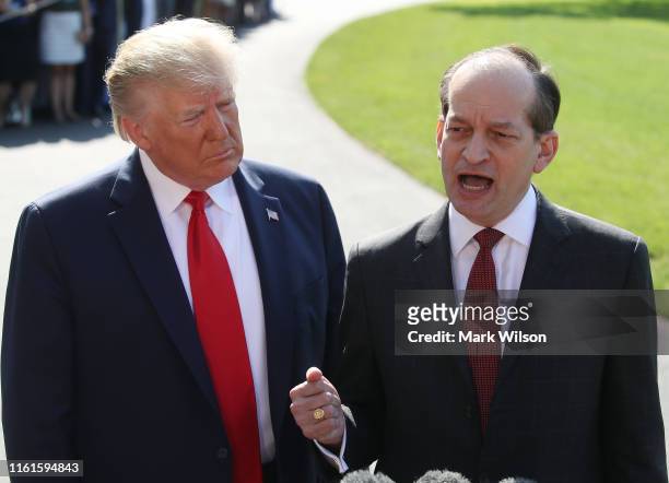 Labor Secretary Alex Acosta stands with U.S. President Donald Trump while announcing his resignation to the media at the White House on July 12, 2019...