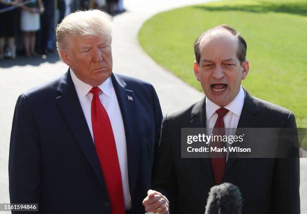 Labor Secretary Alex Acosta stands with U.S. President Donald Trump while announcing his resignation to the media at the White House on July 12, 2019...