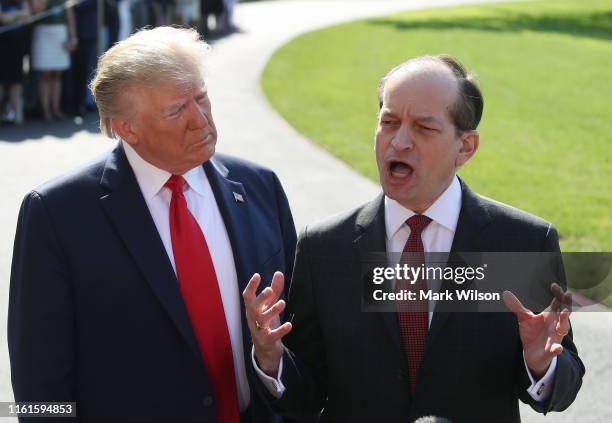 Labor Secretary Alex Acosta stands with U.S. President Donald Trump while announcing his resignation to the media at the White House on July 12, 2019...