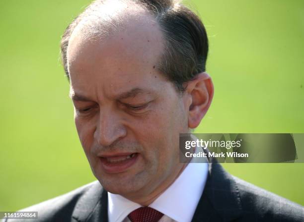 Labor Secretary Alex Acosta stands with U.S. President Donald Trump while announcing his resignation to the media at the White House on July 12, 2019...