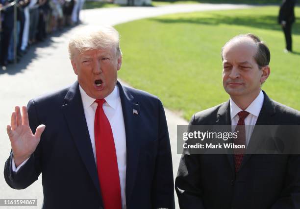 President Donald Trump stands with Labor Secretary Alex Acosta, who announced his resignation, while talking to the media at the White House on July...