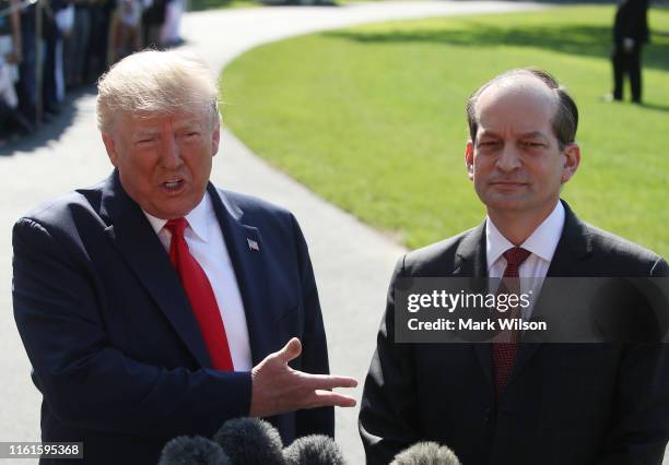 President Donald Trump stands with Labor Secretary Alex Acosta, who announced his resignation, while talking to the media at the White House on July...