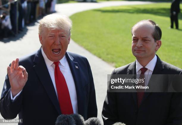 President Donald Trump stands with Labor Secretary Alex Acosta, who announced his resignation, while talking to the media at the White House on July...