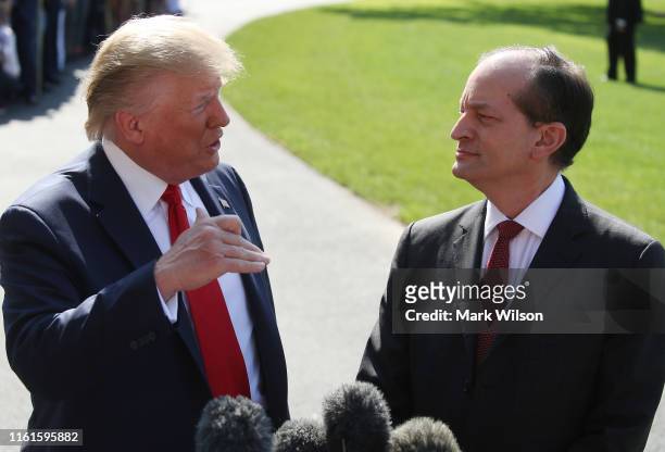 President Donald Trump stands with Labor Secretary Alex Acosta, who announced his resignation, while talking to the media at the White House on July...