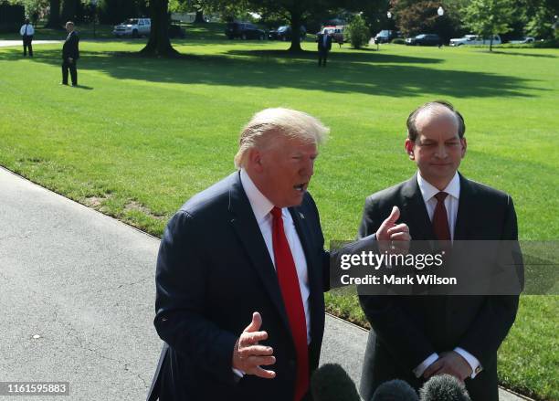 President Donald Trump stands with Labor Secretary Alex Acosta, who announced his resignation, while talking to the media at the White House on July...