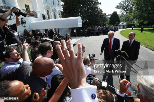 President Donald Trump stands with Labor Secretary Alex Acosta, who announced his resignation, while talking to the media at the White House on July...