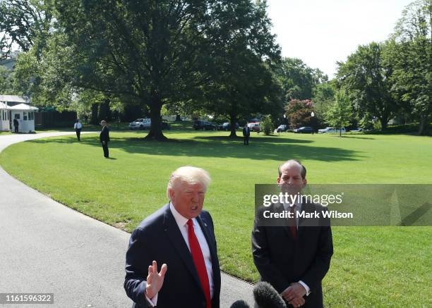 President Donald Trump stands with Labor Secretary Alex Acosta, who announced his resignation, while talking to the media at the White House on July...