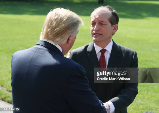 President Donald Trump shakes hands with Labor Secretary Alex Acosta after talking to the media about his resignation, at the White House on July 12,...