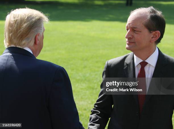 President Donald Trump shakes hands with Labor Secretary Alex Acosta after talking to the media about his resignation, at the White House on July 12,...