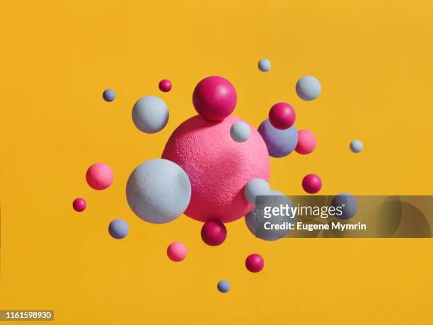 abstract multi-colored spheres on yellow background - art and science stock-fotos und bilder